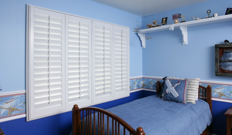Blue kids bedroom with white plantation shutters in Dallas 